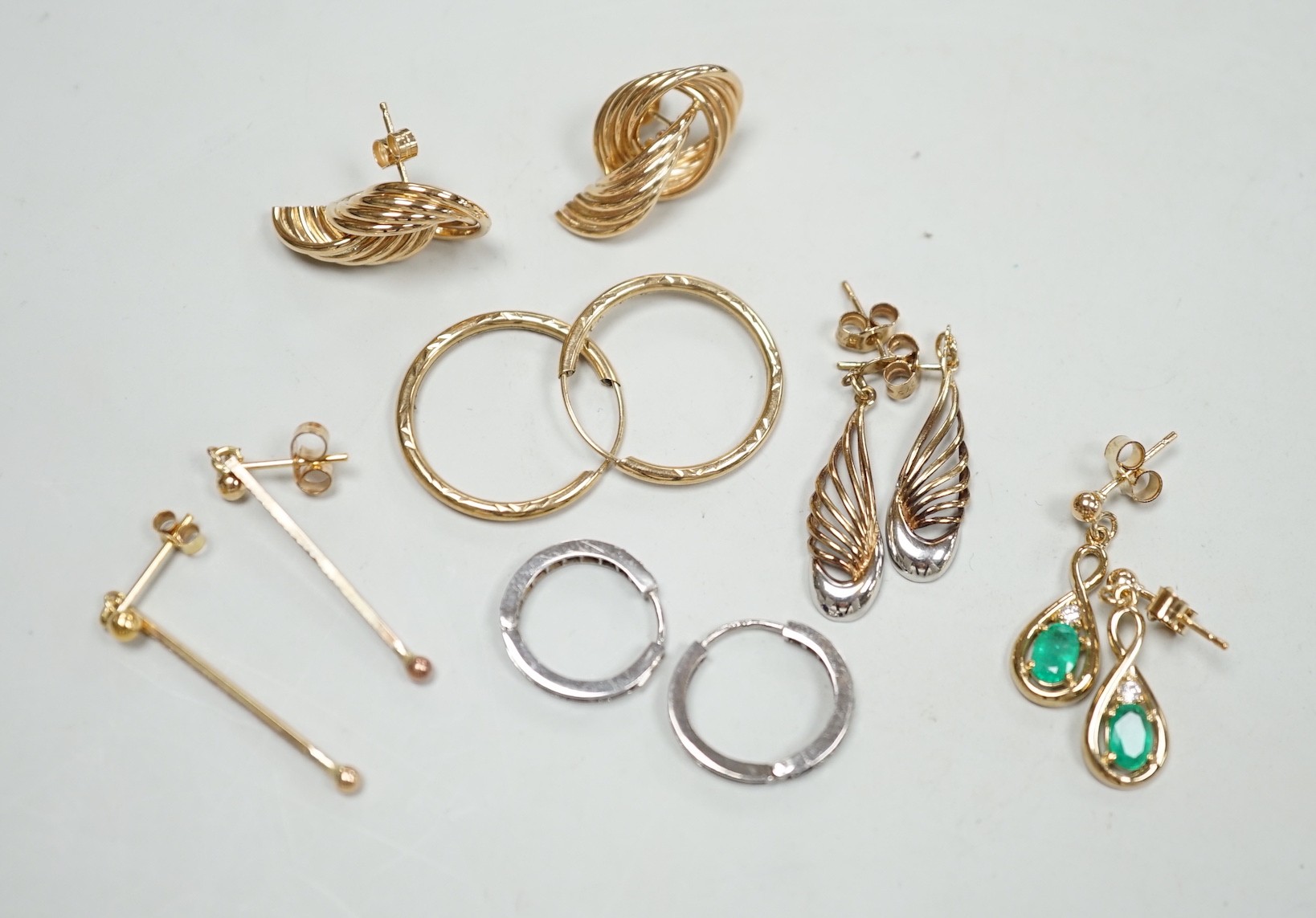 Two modern pairs of 375 earrings, a pair of 9ct, emerald and diamond set drop earrings and a pair of 9ct white gold, sapphire and diamond chip set loop earrings, gross weight 9.2 grams and two pairs of yellow metal earri